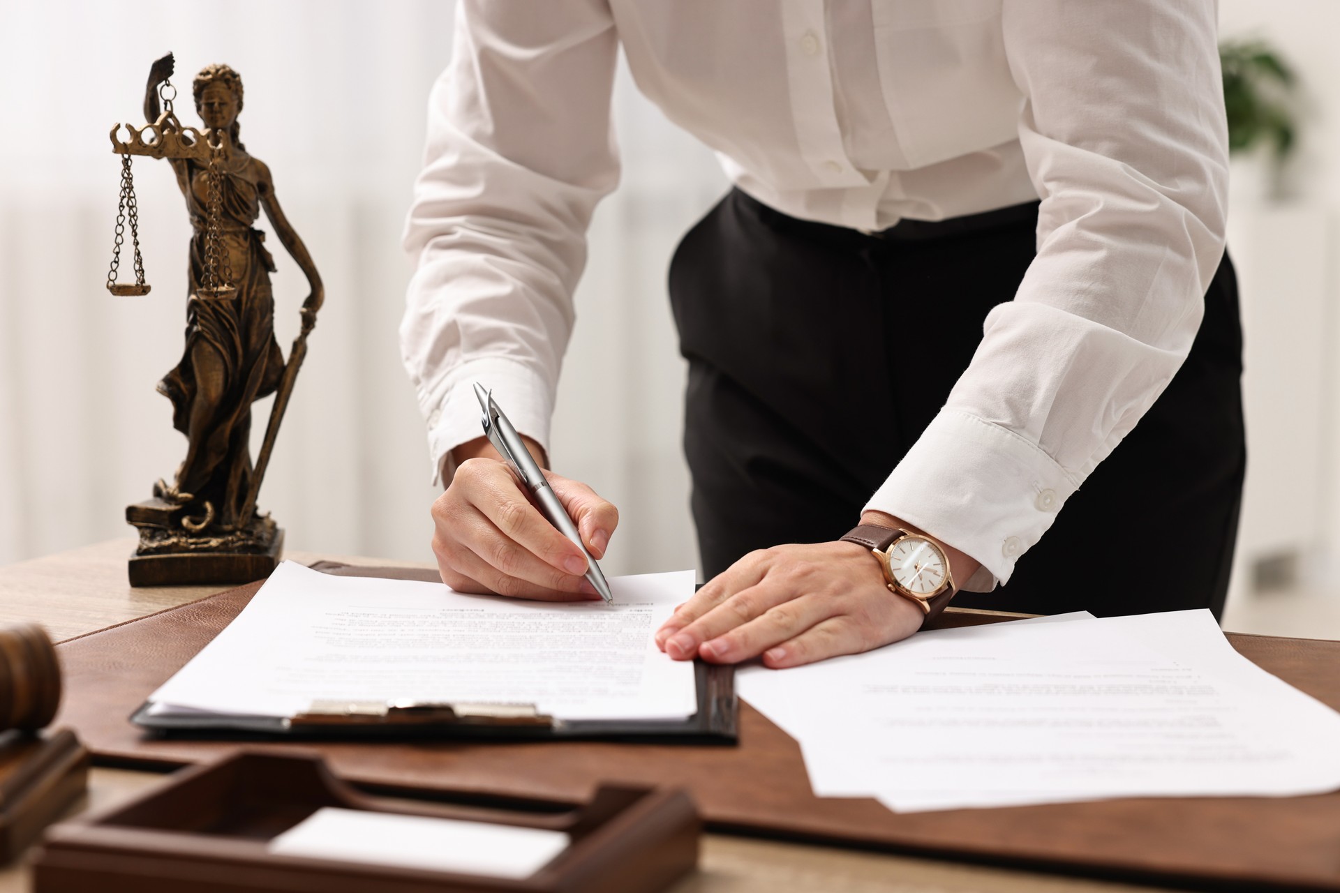 Lawyer working with documents at table in office, closeup